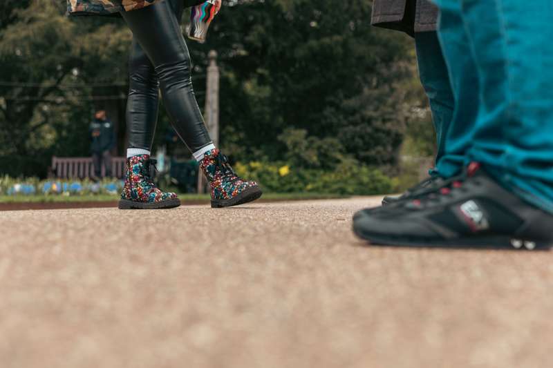 Abstract view of students' feet on a park pathway