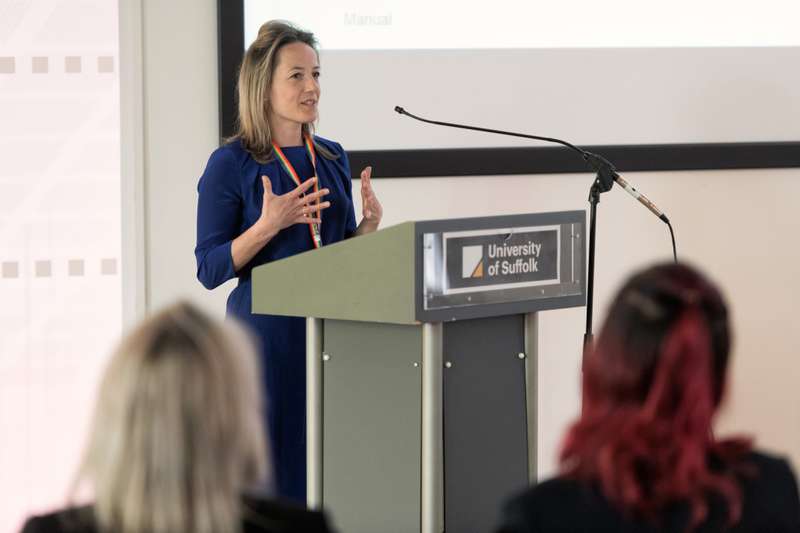 Director of the Legal Advice Centre Eleanor Scarlett standing at a lecture stand speaking to an audience