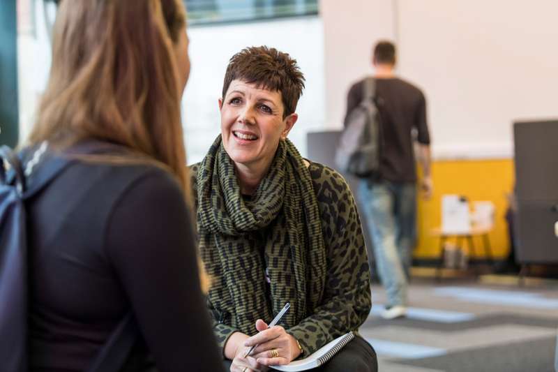 A member of staff talking to a student