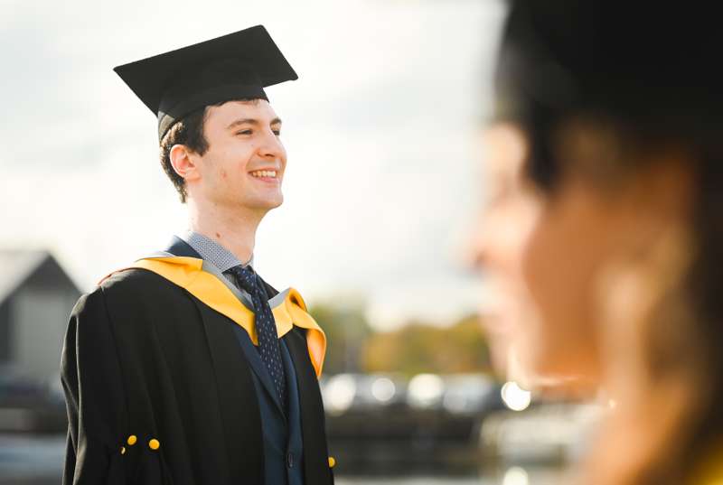 A student standing in their cap and gown
