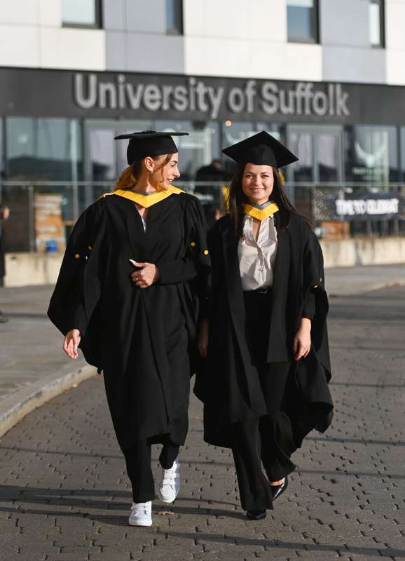 Graduating students walk towards the camera