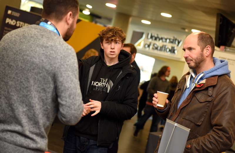 Parent and student talking with staff in a foyer