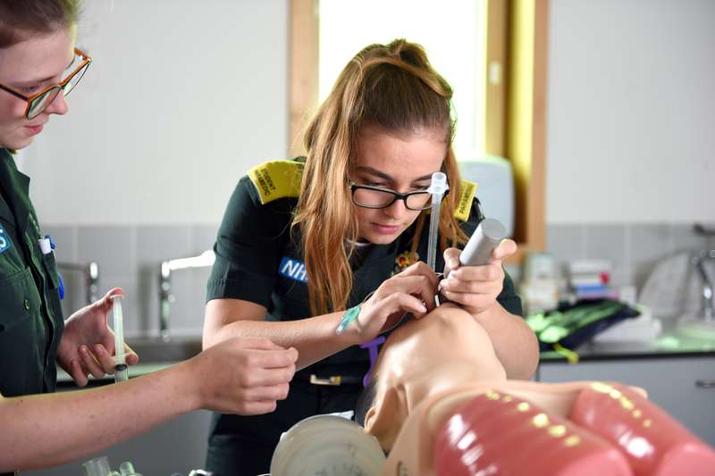 A student paramedic with training manikin