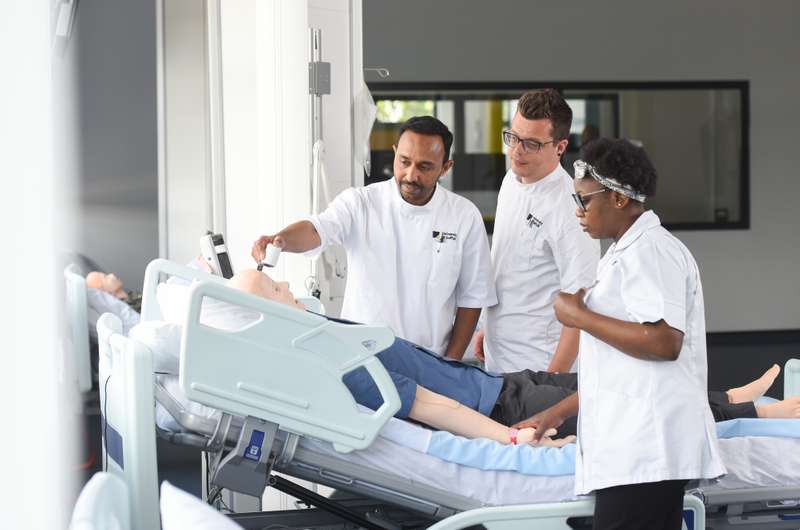 Students at a bedside in a stimulation ward