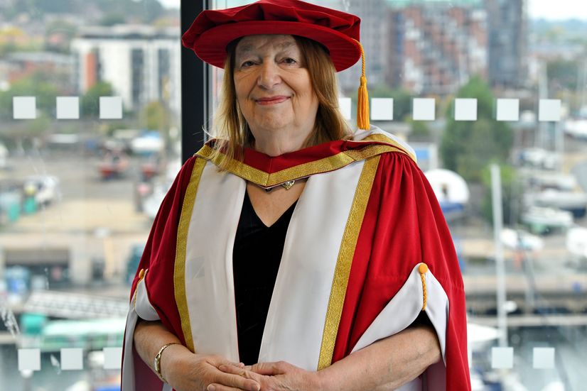 Alison Weir dressed in graduation robes and smiling