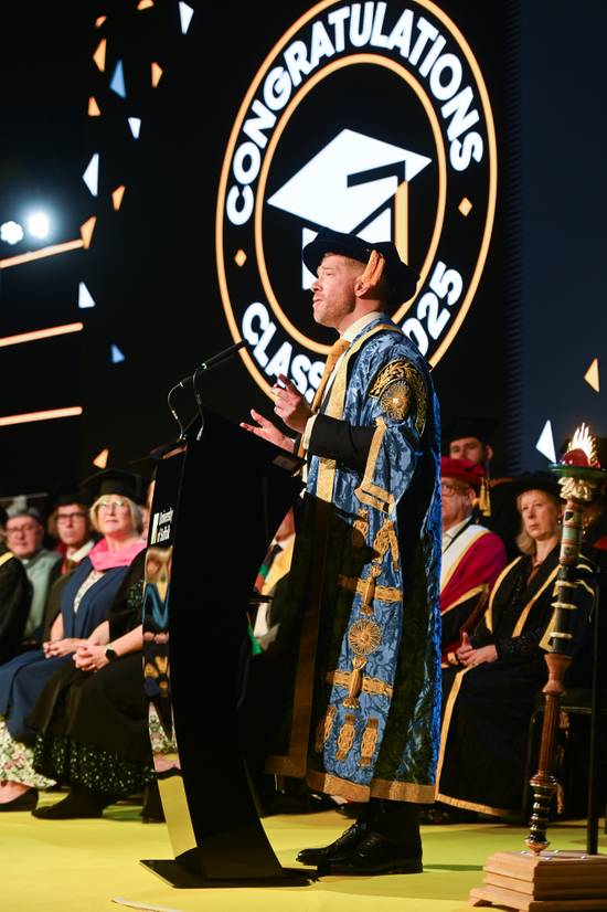Zeb Soanes dressed in Chancellor robes addressing the graduation ceremony