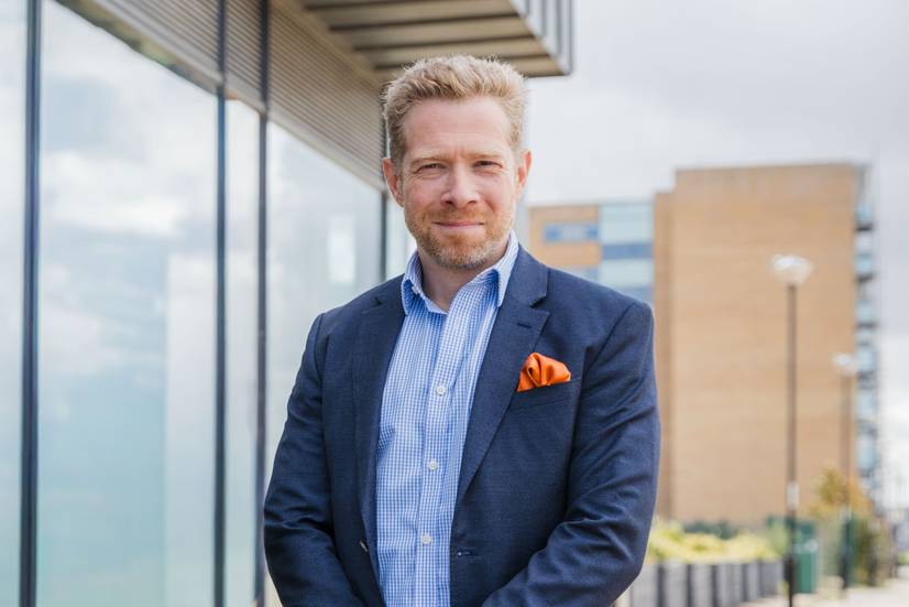 Zeb Soanes standing on Ipswich waterfront, ahead of Zeb becoming the University of Suffolk's new Chancellor