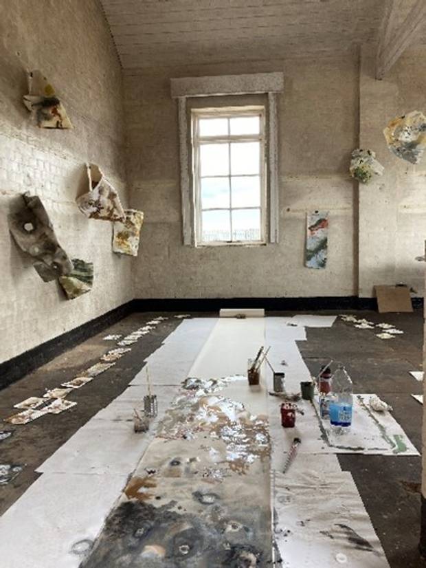 Work being carried out by Dr Jane Watt in the Power House on Orford Ness. Paint and art equipment can be seen on the floor