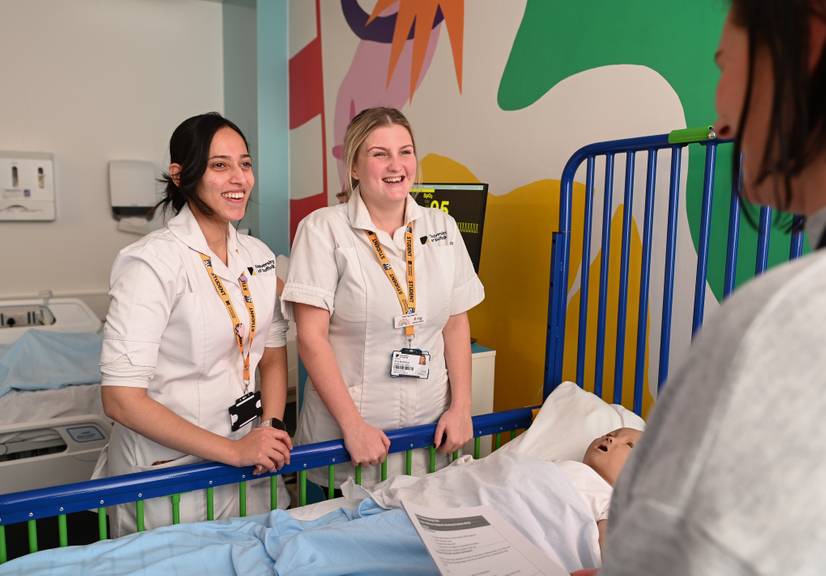 Students standing by a bedside